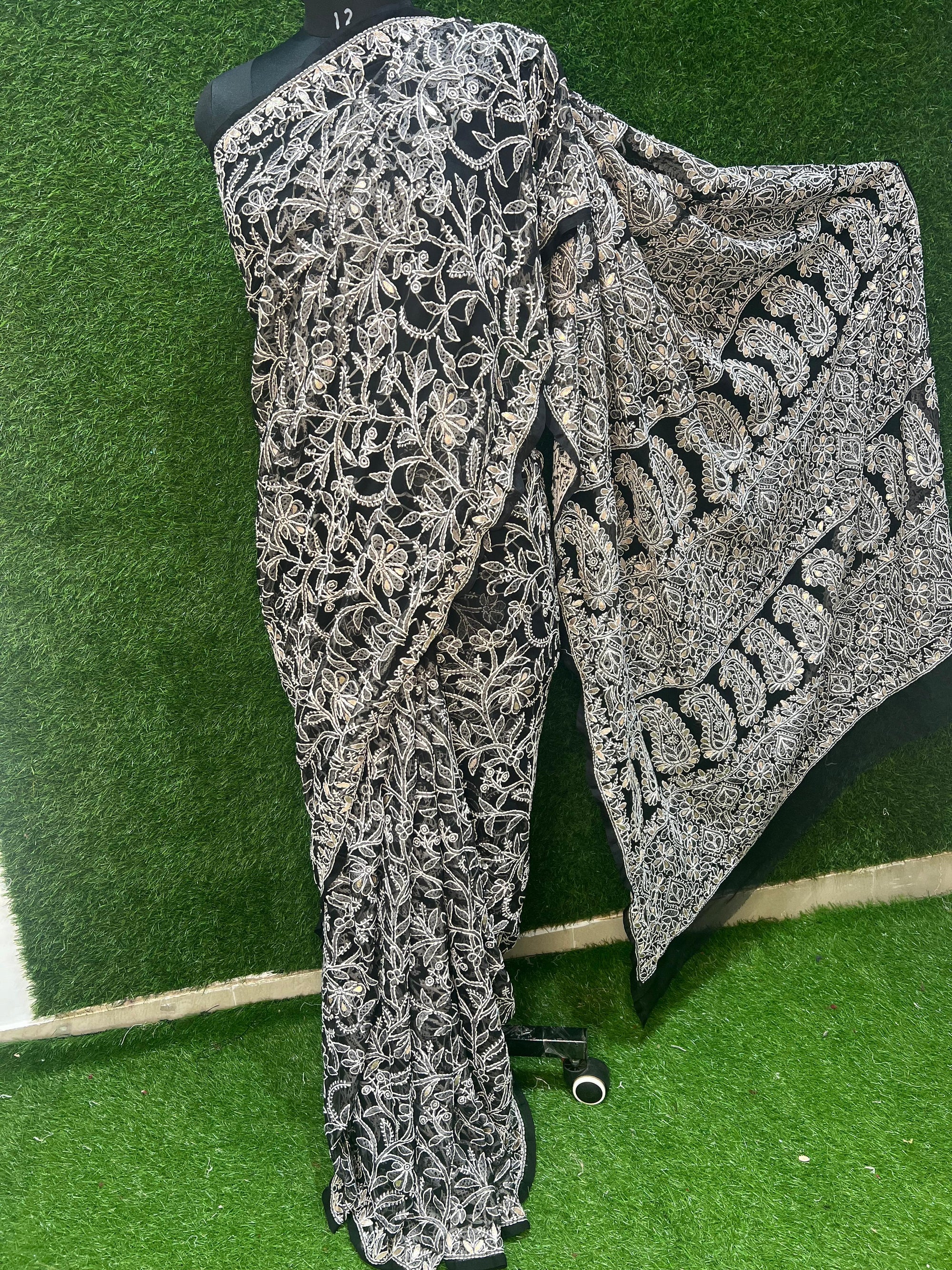 Black Georgette saree, adorned with intricate hand-embroidered Lucknowi Chikankari and enhanced with gota patti work. This masterpiece is a blend of heritage craftsmanship and modern sophistication, making it a perfect choice for special occasions.