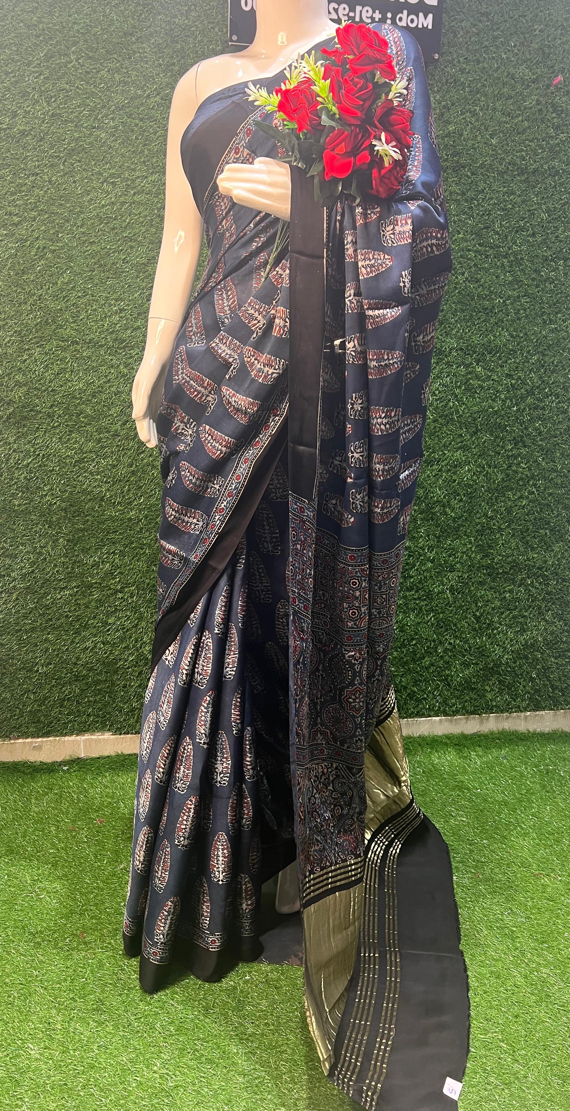 Modal Silk Saree with Ajrakh, a perfect blend of artisanal craftsmanship and luxurious comfort. This saree embodies the beauty of Ajrakh hand block printing, a centuries-old technique that showcases intricate patterns and natural dyes.
