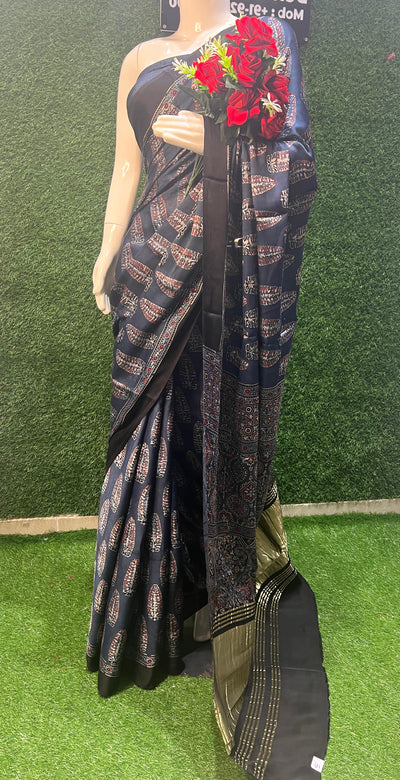 Modal Silk Saree with Ajrakh, a perfect blend of artisanal craftsmanship and luxurious comfort. This saree embodies the beauty of Ajrakh hand block printing, a centuries-old technique that showcases intricate patterns and natural dyes.