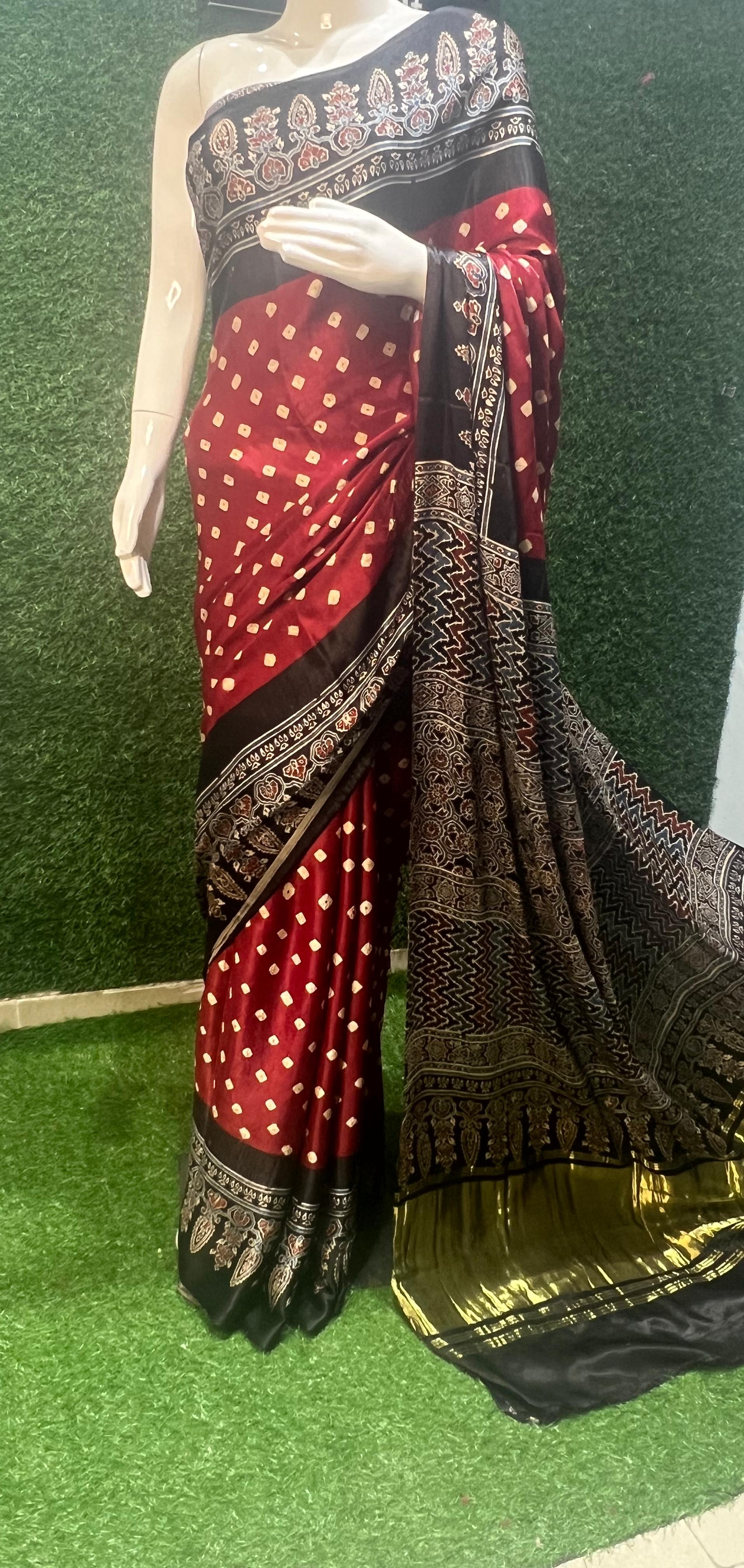 xclusive Modal Silk Ajrakh Bandhej Saree, a masterpiece that beautifully blends the intricate art of Ajrakh printing with the classic charm of Bandhej tie-dye.